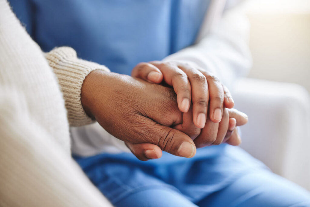 Caregiver comforting a patient recovering at home after a hospital stay